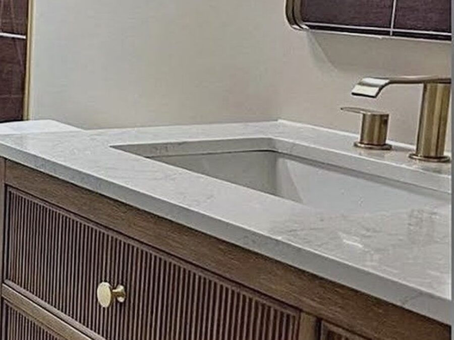 Bathroom vanity with fluted wood cabinet, quartz top and brass faucet